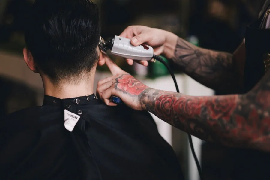 Barbeiro finalizando um corte com a máquina